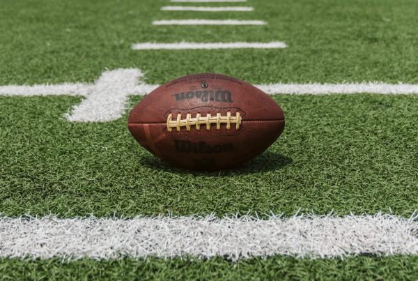 Photo of football on field with a cross